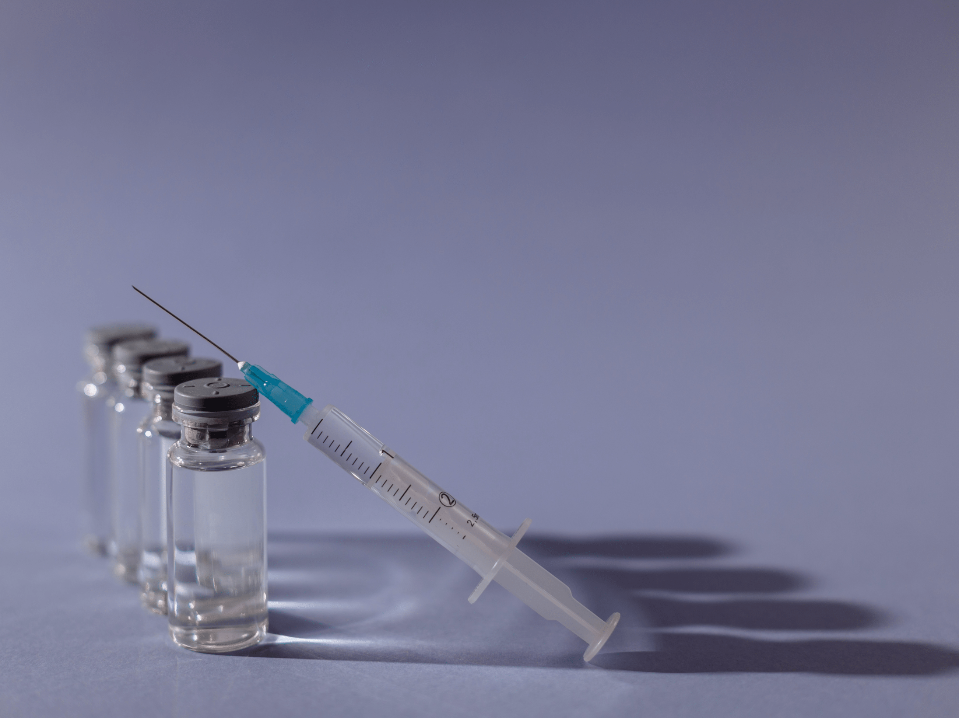 Vier Corona-Impfdosen und eine Spritze