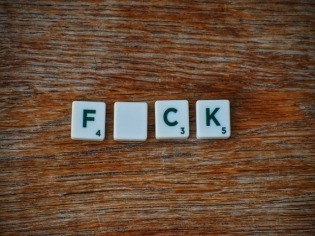 Scrabble-Steine mit den Buchstaben FCK als Symbol für fluchen.